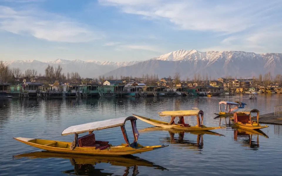 Shikaras on Dal Lake in Srinagar with houseboats and mountains in the background