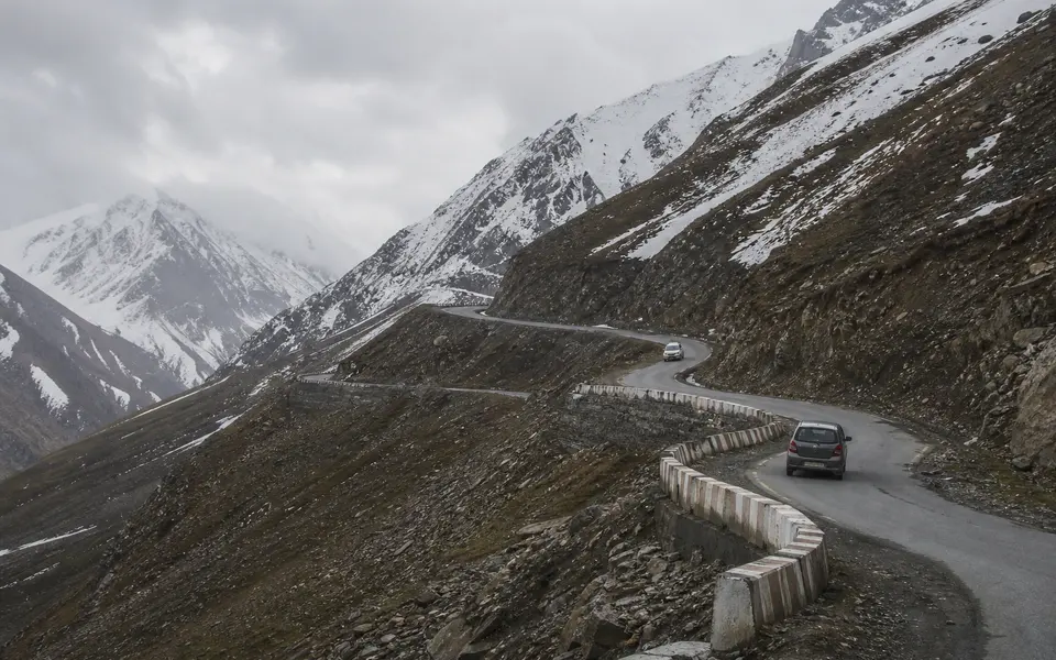 Mountain road with hairpin bends climbing towards Razdan Pass between Bandipora and Gurez, with high slopes and light traffic.