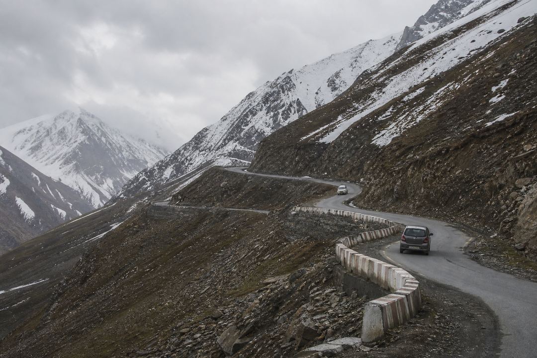 Mountain road with hairpin bends climbing towards Razdan Pass between Bandipora and Gurez, with high slopes and light traffic.
