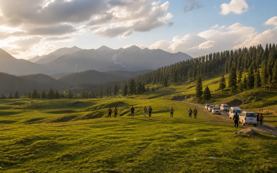 Soft afternoon light over a green high meadow and surrounding hills in Kashmir.
